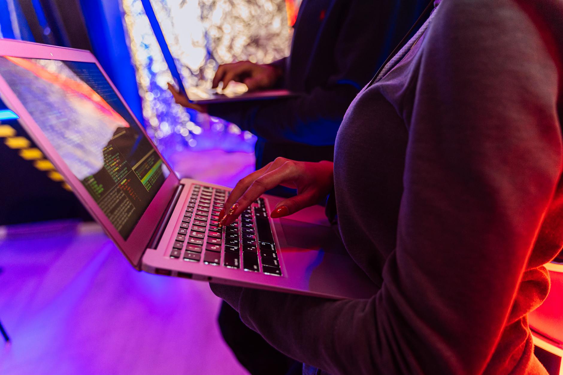 Specjaliści przy laptopach analizują dane o cyberbezpieczeństwie w chmurze