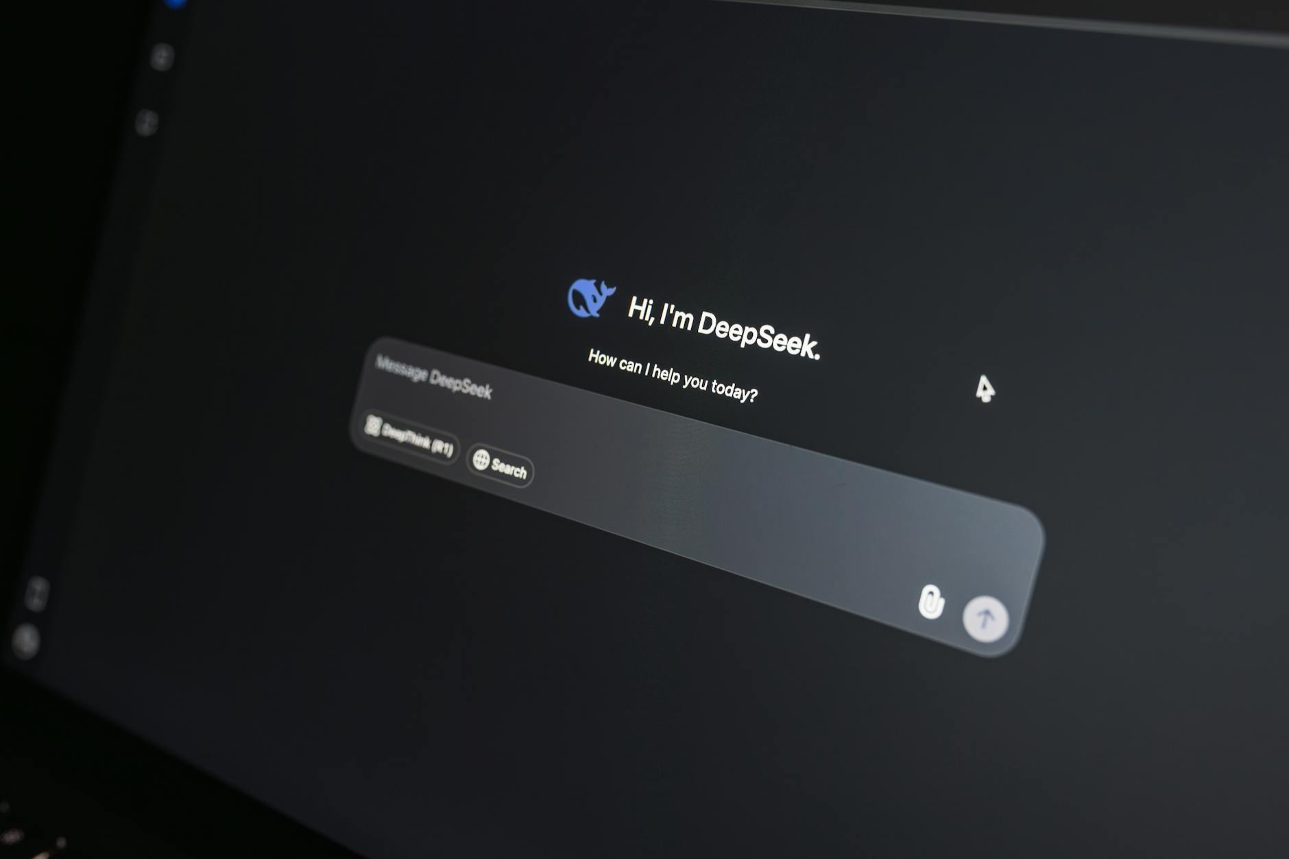 Zbliżenie ekranu laptopa z interfejsem czatu AI w ciemnym otoczeniu