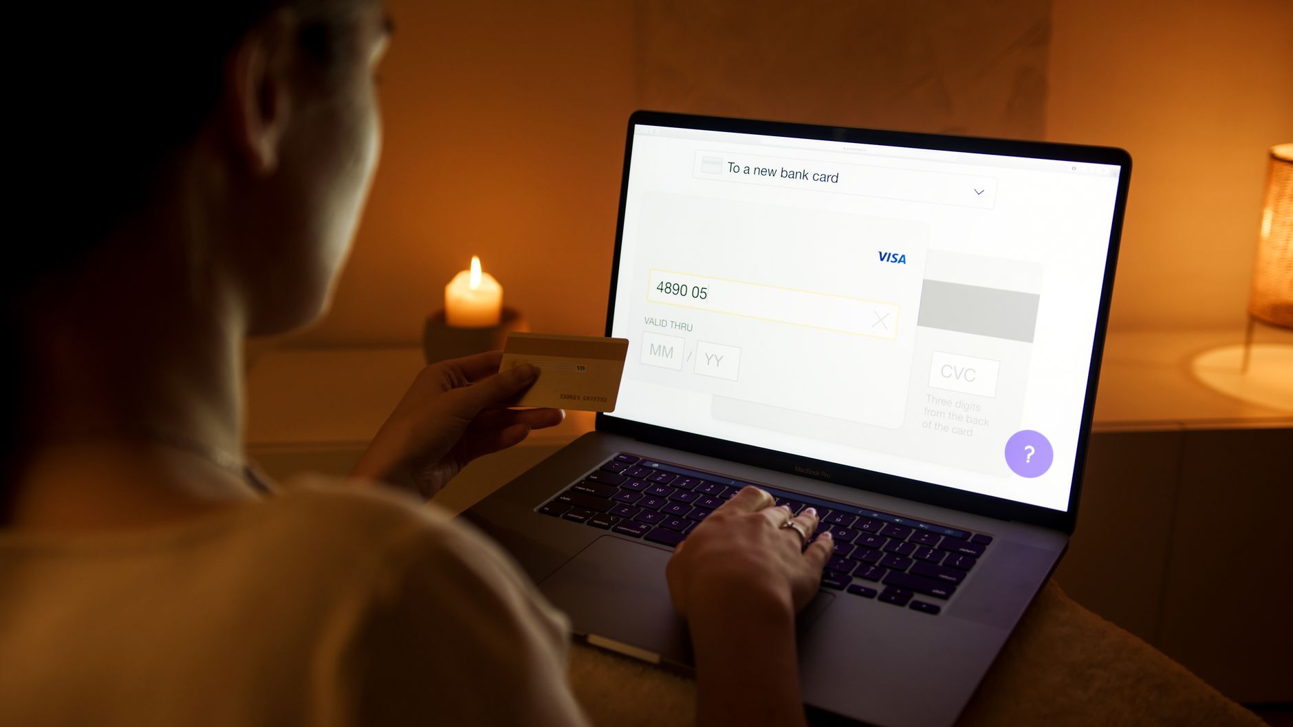Kobieta płaci kartą online na laptopie w domowym otoczeniu